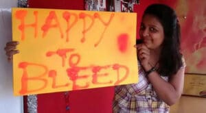 Mujer con un cartel "Happy to Bleed"